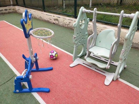 安河家园闲置的门球场内，家长们自行添置了儿童设施。