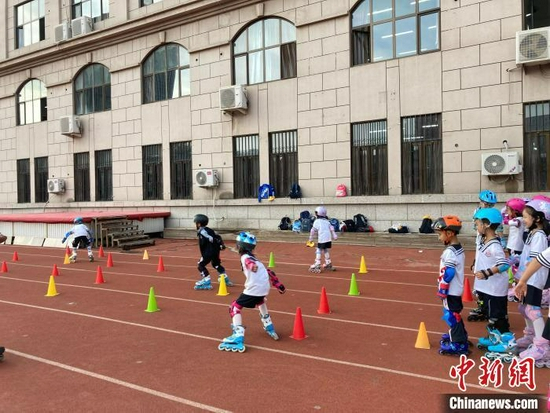 资料图：放学后在操场学习轮滑的学生。　徐婧 摄