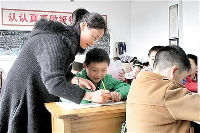 班主任苏妮正纠正夏世钢用笔姿势。