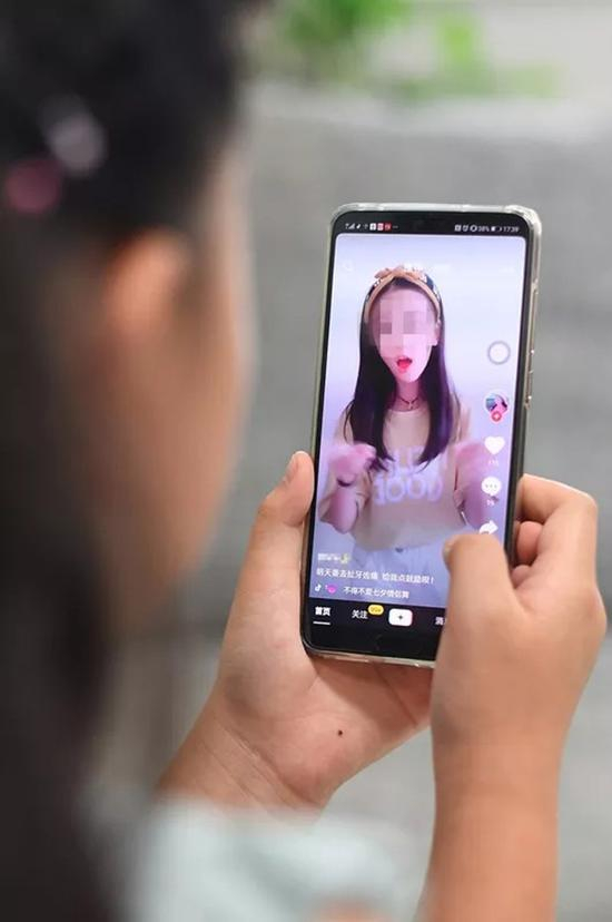 一个小女孩在观看抖音里的视频