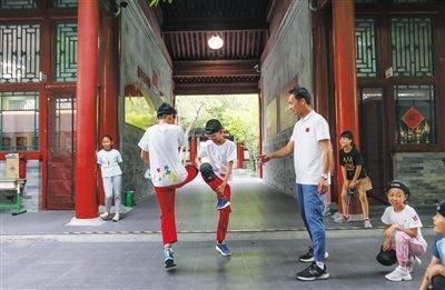 6月11日，新鲜胡同小学，学生在老师的辅导下进行脚斗娃体验。新京报记者 李木易 摄