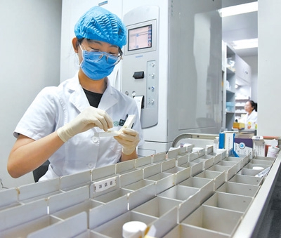北京儿童医院病房药房内，药师在分割药片。北京儿童医院供图