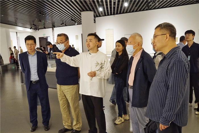 沈国麟(中)在展览现场导览