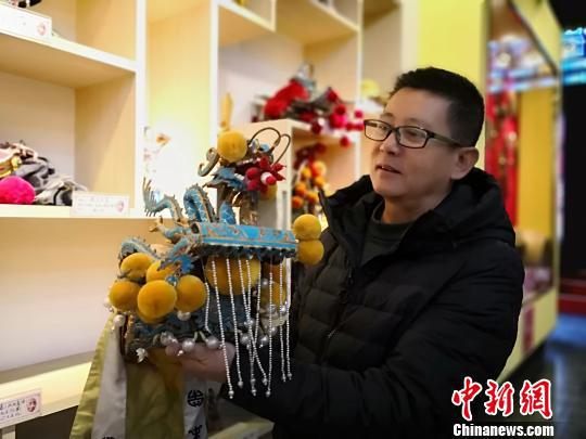 图为李丹宇介绍崆峒笑谈剧团表演服装。　魏建军 摄