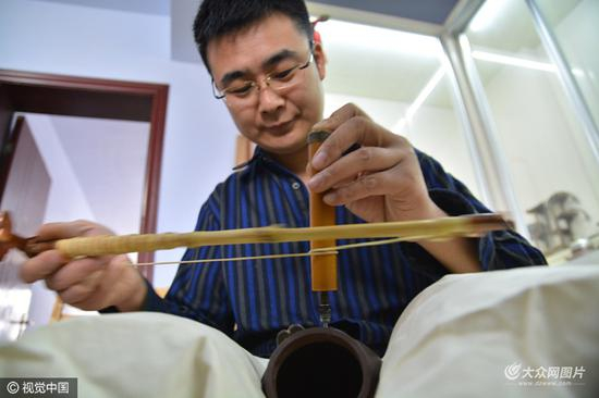 唐立果正在给一把紫砂壶钻眼。图片作者：刘明照/视觉中国