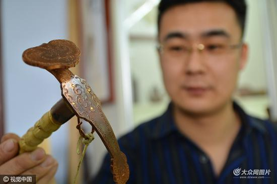 　　唐立果拿着一把弓子说，弓子头上的“如意”是纯铜的，他手工制作，寓意客户把器具交给自己，他要用心修补，客户和自己双方都如意。