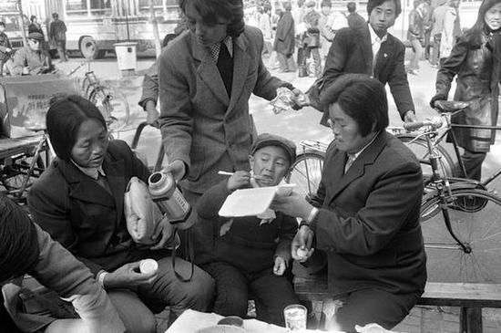 　　前门地区，吃盒饭的人们。北京，1986年。[摄影：Guy Le Querrec]