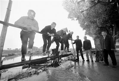 几位老人在演示踩水车