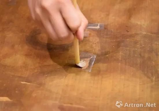 修复师将手工纸放在有撕裂处的背面，并糊上小麦淀粉