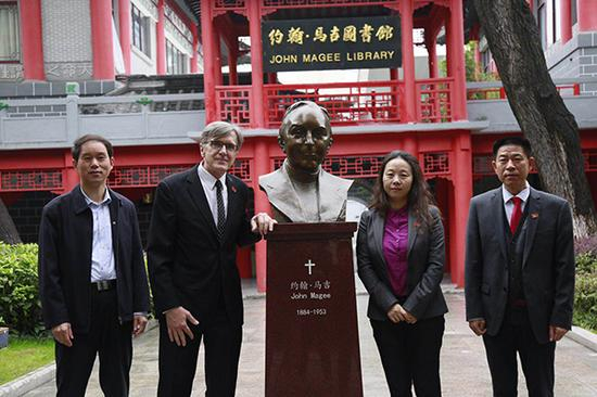 参加仪式的嘉宾与约翰·马吉雕像合影