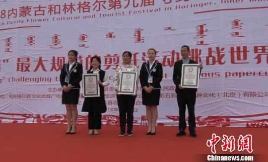 图为世界纪录认证机构认证官为活动主办方颁发证书。　马知远 摄
