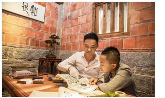 〈图一〉林志坚先生在给下一代讲解古钱知识，这就是一种传承