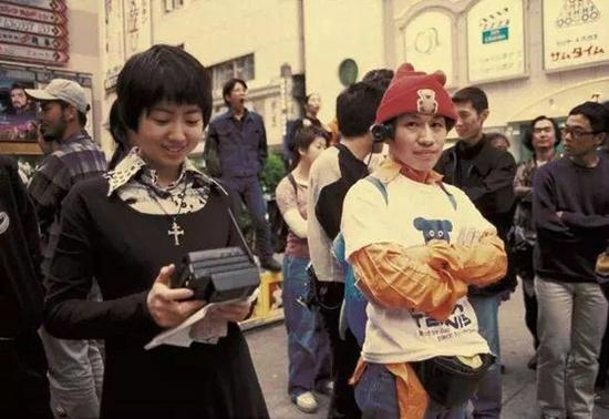 　　八谷和彦的行为表演，1994年，他使用了随身携带的摄像机、电讯发射器和录像机做现场记录。图片来源：中间美术馆