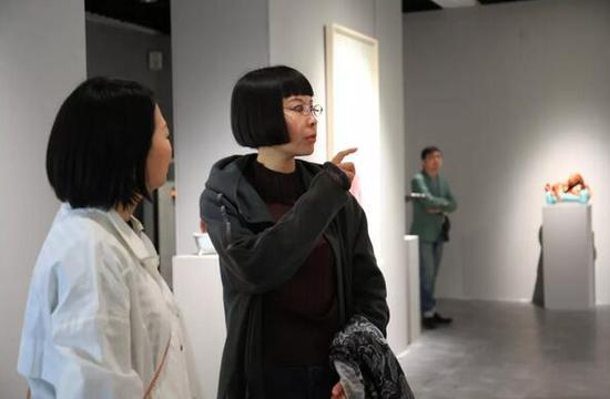 展览艺术家丁荭（右一）与艺术家米玉明交流