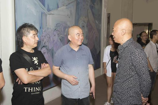 艺术家王劲松（左）与策展人冀少峰（中）、艺术家许仲敏