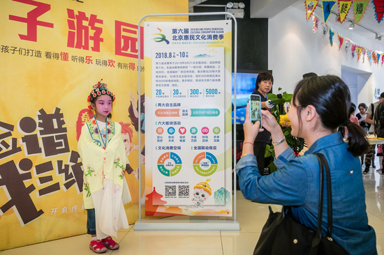 图为小朋友在背景板前合影留念