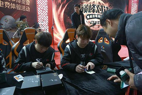 两位专业电竞选手为钱币爱好者签售腾讯电竞2018亚运会纪念章