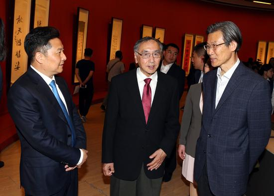 朱奕龙（左一）与于中令（中）在展览现场就本次展览热烈交流