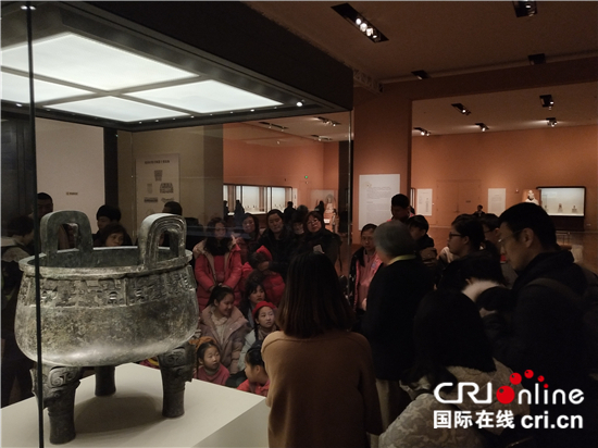 国家博物馆内，观众通过讲解员的介绍深入了解展品。