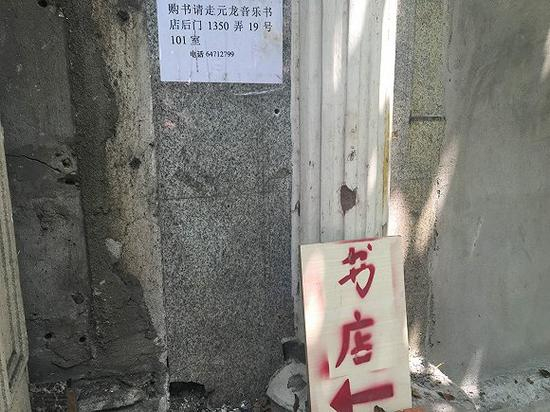 砌上墙的大门边贴着告示，还有一个手写的方向指示牌