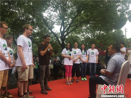 图为中法志愿者向古建筑工匠奉茶“拜师” 李佳赟 摄
