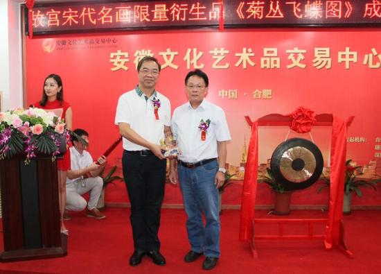 （为《菊丛飞蝶图》挂牌方颁发艺术品水晶纪念牌）