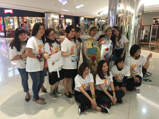 活动参与者与爱心雕塑合影