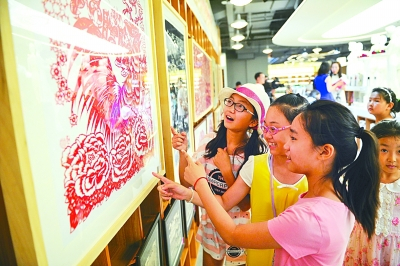 非遗剪纸作品吸引学生驻足欣赏。 光明图片/视觉中国
