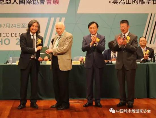 　　赠书仪式主礼嘉宾吴为山教授向卢斯塔尼亚人国际协会代表Roberto Vecchi教授赠送葡文版《吴为山的雕塑世界》