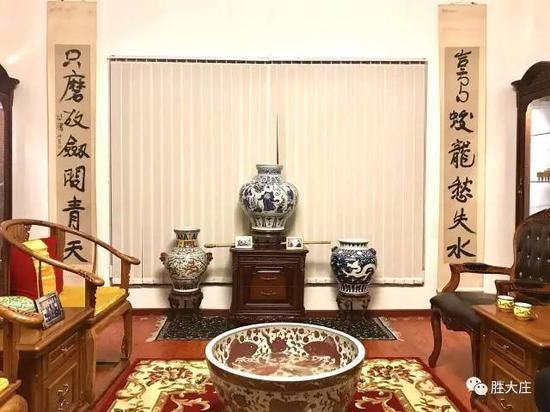 　　迎面正中央是元青花唐太宗和番狮头双耳大罐 右边是明宣德青花彫瓷云龙双狮耳罐 左边是明万历五彩双龙拱珠龙凤双狮耳罐 旁边是徐悲鸿特大对联 [岂有蛟龙愁失水 只磨故剑问青天]
