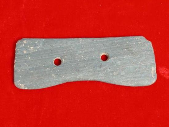 哈休遗址出土的涂红双孔石钺