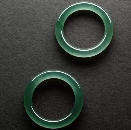 这对手镯采用顶级晴水料，质地之完美无瑕，色泽之光华内敛，如一汪空谷幽潭，静谧深流。