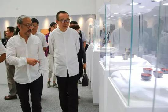 艺术家翁纪军与中国文联副主席潘鲁生在展览现场观看日本漆艺部分