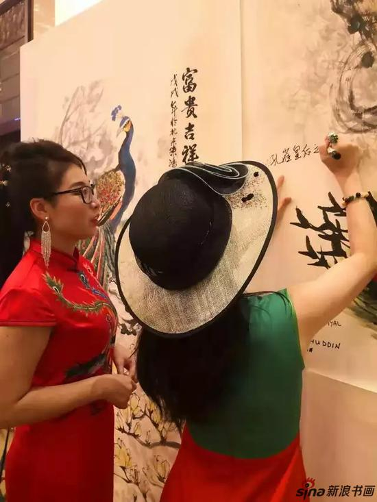 余淑琴女士给陈鸿孔雀作品，签字合影留念