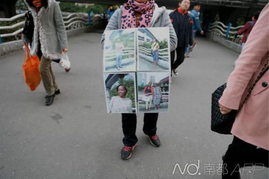 　　小北人行天桥上，一名在街头拍快照的商人在路中间招揽生意，她用于展示的相册里，大部分拍摄对象都是外国人。