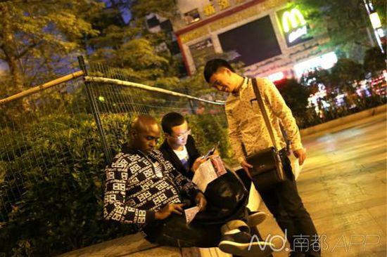 小北地铁站出口，两名货运公司职员向一名外籍男子推销他们的货运服务。