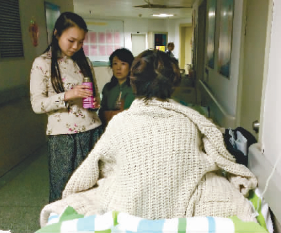 　　昨晚，武汉大学中南医院妇产科病房过道里，早产孕妇朱女士已可坐起，好心乘客张女士（左一）和李女士（左二）一直陪护着她 记者任勇 摄