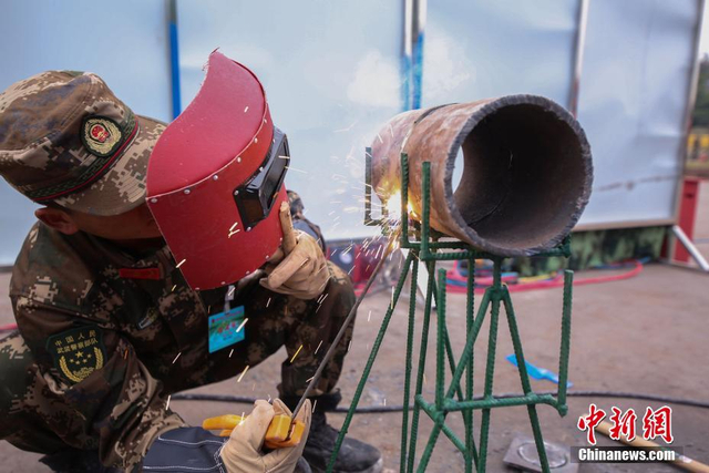 驻渝武警水电部队进行大比武 挖掘机倒酒写毛笔字