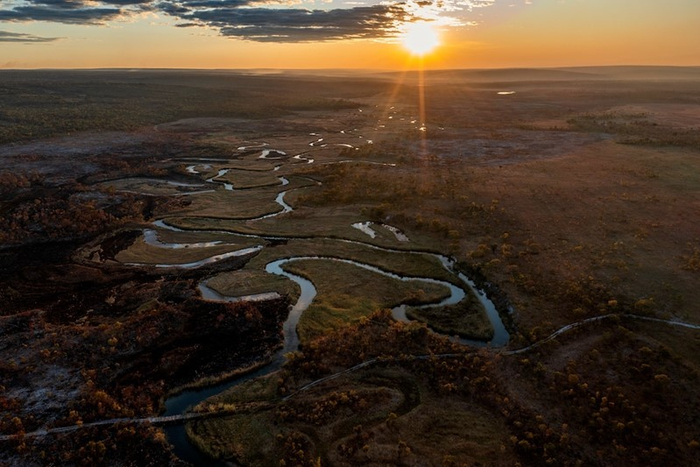 俯瞰日落映照于安哥拉隆圭本古河弯曲细长的上游。© National Geographic/Jen Guyton