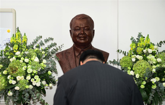 1月8日,到场人士在追思仪式上向黄大年纪念雕像鞠躬.