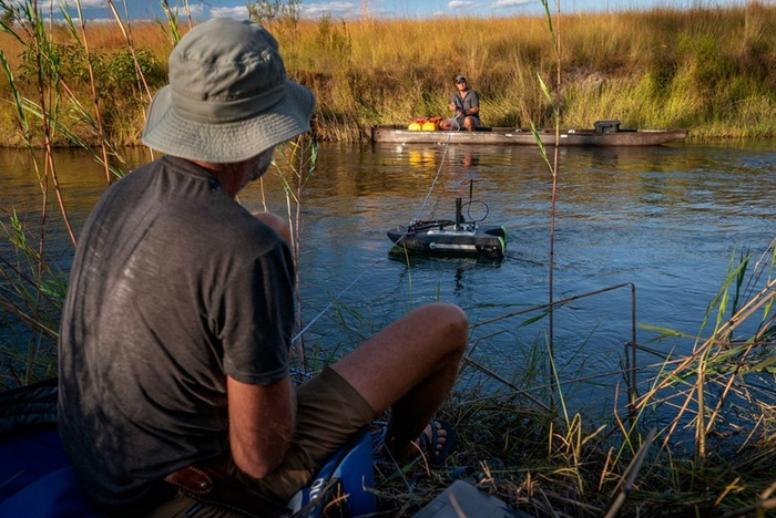 研究总监雷纳・冯・布兰迪斯和研究经理格茨・尼夫在隆圭本古河沿岸设置声学多普勒流速剖面仪，以绘制河床剖面图并测量其流量。©National Geographic/Jen Guyton