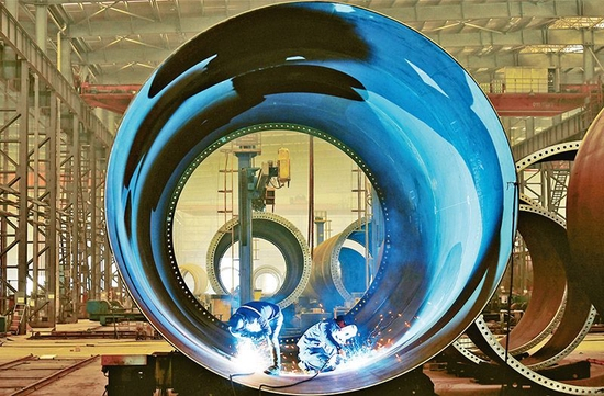 图为2023年2月8日，江苏省太仓港经济技术开发区，苏州天顺新能源科技有限公司生产人员正在焊接风电塔筒单节筒体，奋力实现首季“开门红”。 人民图片 计海新/摄