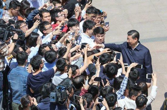 2018年5月2日，习近平来到北京大学考察。图为习近平离开学校时同道路两旁师生亲切握手。 新华社记者 王晔 摄