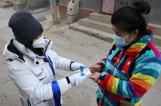 工作人员为村民发放出入证