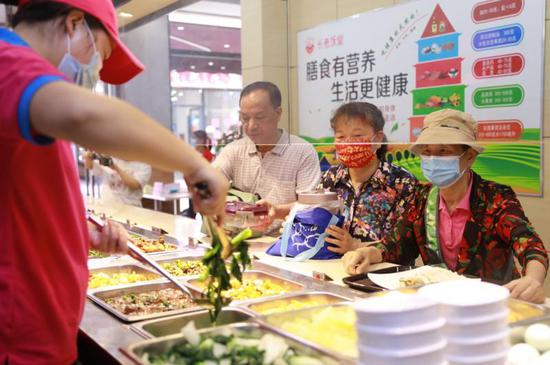 老人在长者饭堂挑选自己喜欢的菜品。