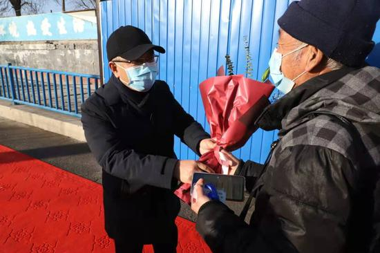 南法信地区党委书记李光明为东海洪村村民送花