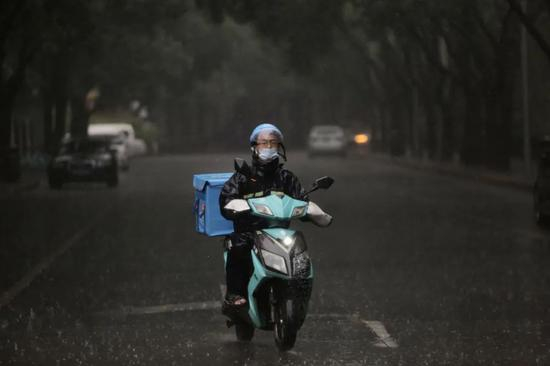  外卖员冒雨送餐。新京报记者 郑新洽 摄