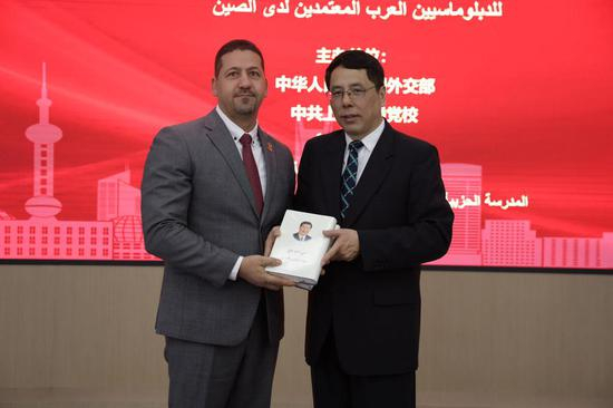  巴勒斯坦驻华大使馆参赞艾布扎尔格在上海市委党校获赠阿文版《习近平谈治国理政》第一、二卷。