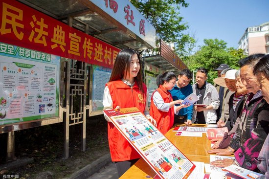志愿者为村民普法（图源：CFP）