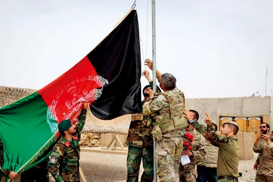 5月2日，阿富汗士兵与美军士兵在赫尔曼德省一处军事基地升起阿富汗国旗。当日，美军向阿富汗国民军移交该处军事基地。图/新华